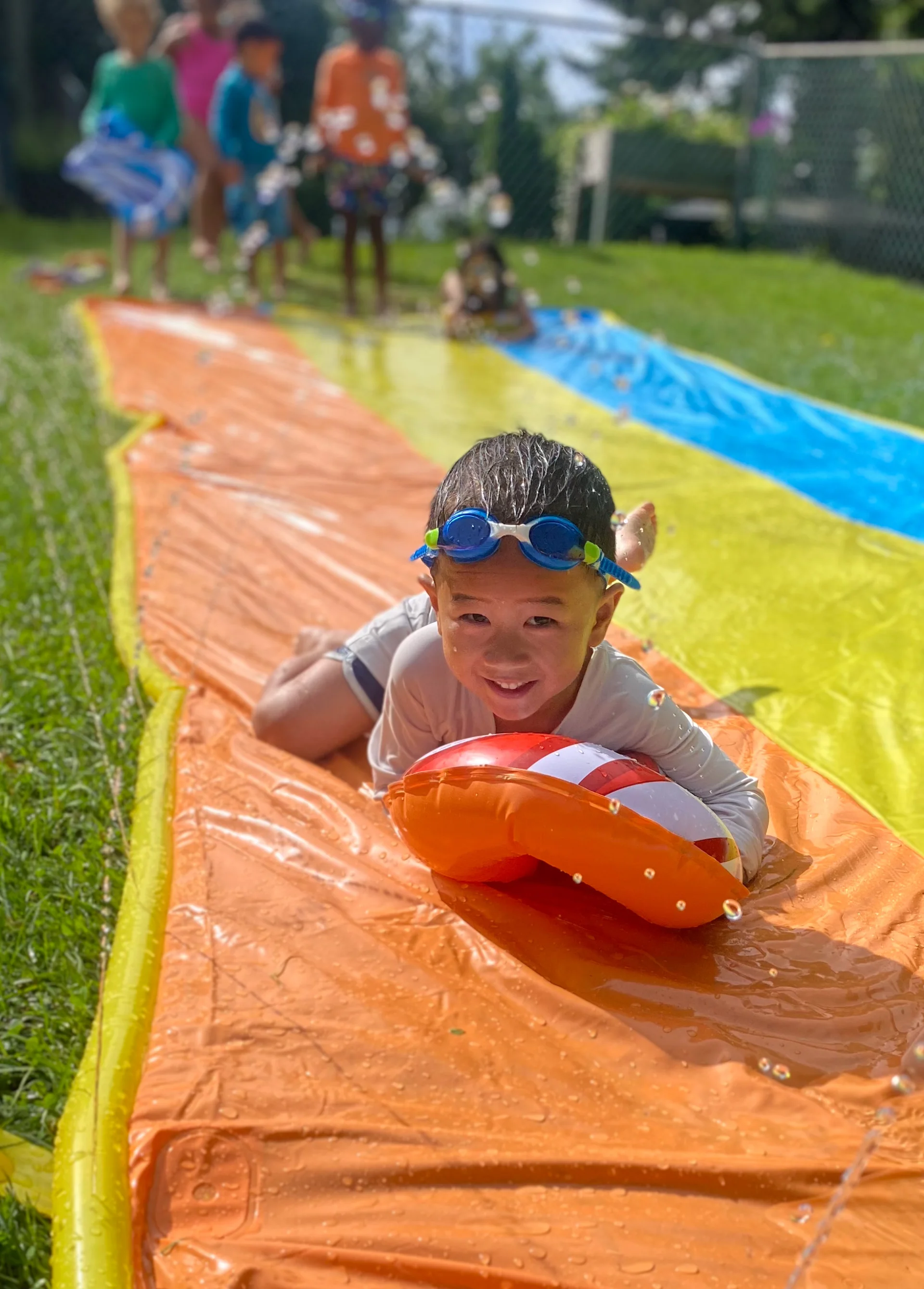 boy sliding on a wet slide in summer camp in yonkers